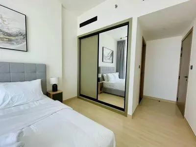 a bedroom with a white bed and a large mirror at Jvc 1br Apartment Modern Comfort, Pool, Parking in Dubai
