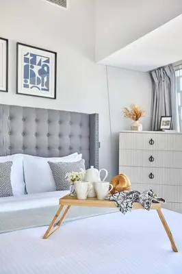 a bedroom with a bed with a wooden tray with dishes on it at Frank Porter - Cayan Tower in Dubai