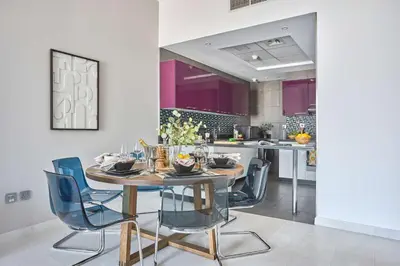 a dining room with a table and blue chairs at Frank Porter - Cayan Tower in Dubai