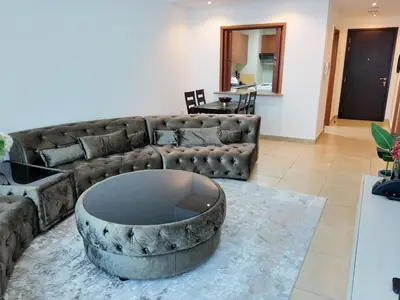 a living room with a couch and a table at Spacious 1 Bedroom Plus Hall in Mag218 in Dubai