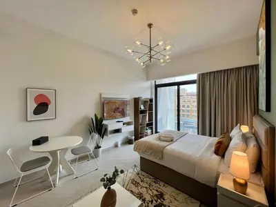 a bedroom with a large bed and a table and chairs at Prime Studio in the Heart of JVC-Dubai in Dubai
