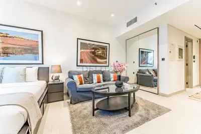 a bedroom with a bed and a couch and a table at Near Circle Mall and steps from the park, Hyati Avenue, JVC by Deluxe Holiday Homes in Dubai
