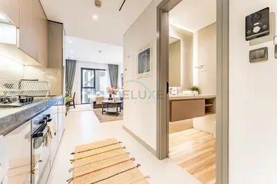 a view of a kitchen and living room from the hallway at Near Circle Mall and steps from the park, Hyati Avenue, JVC by Deluxe Holiday Homes in Dubai