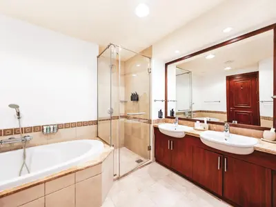 a bathroom with two sinks and a tub and a shower at New Fairmont Residence with private beach on PalmJumeirah in Dubai