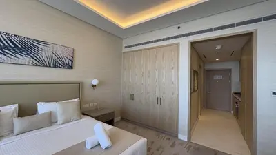 a hotel room with a bed and a hallway at Ultra-Luxury Studio Palm Tower St. Regis Views High Floor DRP Holiday Homes in Dubai