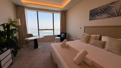a hotel room with a bed and a large window at St. Regis Sky Residence at Palm Tower by DRP Holiday Homes in Dubai
