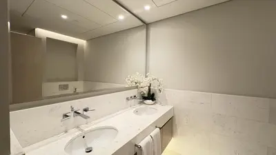 a white bathroom with a sink and a mirror at St. Regis Sky Residence at Palm Tower by DRP Holiday Homes in Dubai