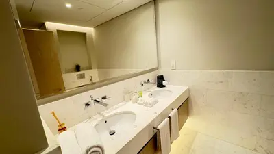 a bathroom with a sink and a large mirror at St. Regis Sky Residence at Palm Tower by DRP Holiday Homes in Dubai