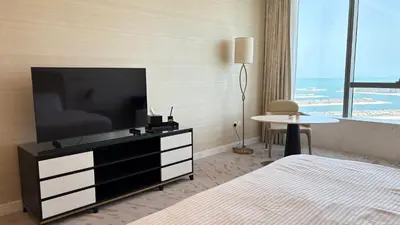 a hotel room with a flat screen tv and a bed at St. Regis Sky Residence at Palm Tower by DRP Holiday Homes in Dubai