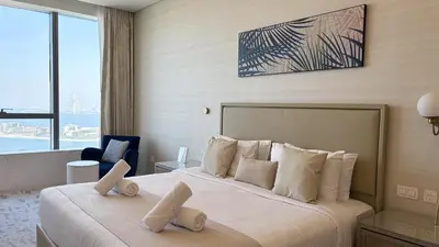 a bedroom with a large bed with white pillows at St. Regis Sky Residence at Palm Tower by DRP Holiday Homes in Dubai