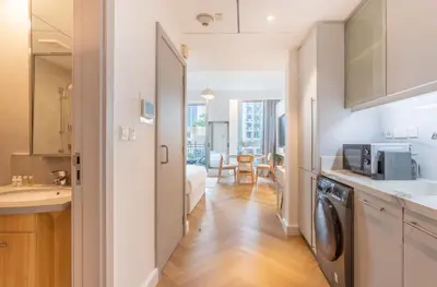 a kitchen with a washer and dryer in a apartment at Vacationer I Luxe Studio I Steps to Burj Khalifa & Dubai Mall I Free Parking, Pool, Gym & Wi-Fi in Dubai