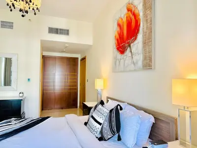 a bedroom with a bed and a painting on the wall at Stylish 1BHK in Marina Steps to Metro & Marina Walk in Dubai