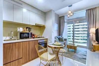 a kitchen with a table and chairs and a living room at 1BR Apartment with Canal View near Dubai Mall & Burj Khalifa in Dubai