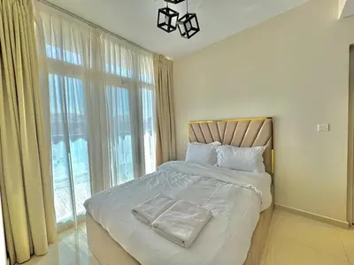 a bedroom with a bed and a large window at 3 BR Fully Furnished with BBQ Griller in Dubai