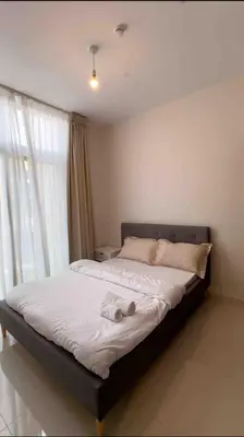 a bed in a room with a large window at 3 BR Fully Furnished with BBQ Griller in Dubai