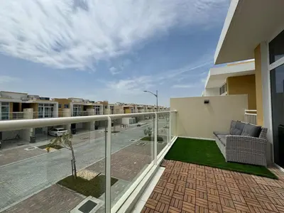 a balcony with a couch and a view of a street at 3 BR Fully Furnished with BBQ Griller in Dubai