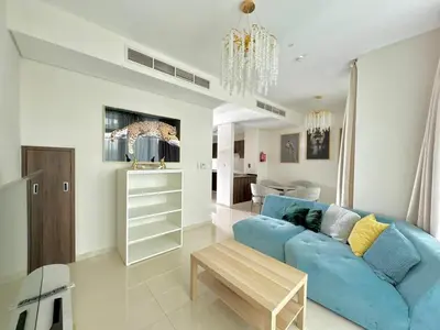 a living room with a blue couch and a table at 3 BR Fully Furnished with BBQ Griller in Dubai