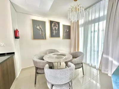 a dining room with a table and chairs and a chandelier at 3 BR Fully Furnished with BBQ Griller in Dubai