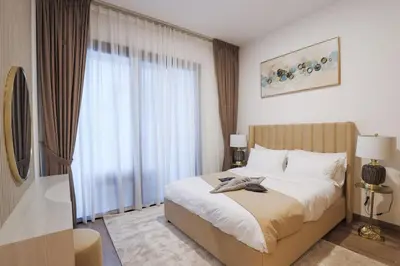 a bedroom with a bed and a large window at Chic 2BR in Oakley Square Residence, JVC in Dubai