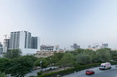 a city with cars driving down a street with buildings at Chic 2BR in Oakley Square Residence, JVC in Dubai