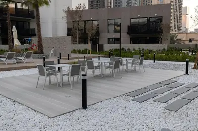 a group of tables and chairs in front of a building at Chic 2BR in Oakley Square Residence, JVC in Dubai