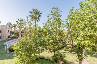 an apple tree in a park with a pool at Near the Beach 4BR Villa with Assistant's Room, Minutes Away from the Mall and Monorail, Canal Cove, Palm Jumeirah by Deluxe Holiday Homes in Dubai