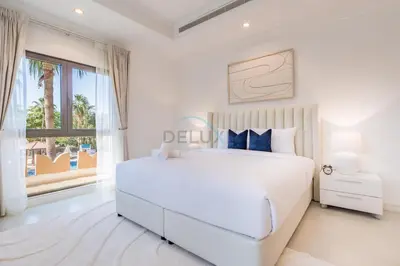 a white bedroom with a large bed and a window at Near the Beach 4BR Villa with Assistant's Room, Minutes Away from the Mall and Monorail, Canal Cove, Palm Jumeirah by Deluxe Holiday Homes in Dubai