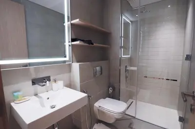 a bathroom with a toilet and a sink and a shower at Luxurious 2BR in Oakley Square Residence, JVC in Dubai