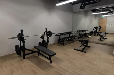a gym with rows of exercise equipment in a room at Luxurious 2BR in Oakley Square Residence, JVC in Dubai