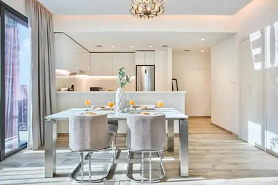 a kitchen and dining room with a white table and chairs at Bright and Modern City Apartment in Business Bay with Two Balconies, Pool, Gym, free Parking and Self Check In, Sleeps up to Four, by Stayfinity in Dubai
