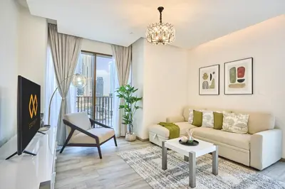 a living room with a couch and a tv at Bright and Modern City Apartment in Business Bay with Two Balconies, Pool, Gym, free Parking and Self Check In, Sleeps up to Four, by Stayfinity in Dubai