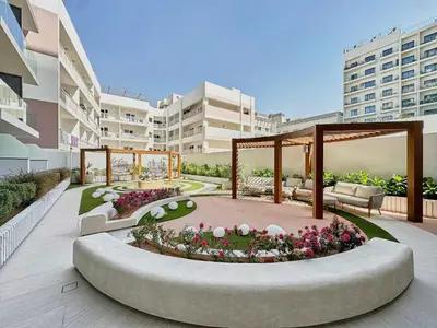 a garden with a seating area in a building at Frank Porter - Gemz by Danube in Dubai