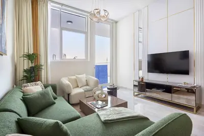 a living room with a green couch and a tv at Frank Porter - Gemz by Danube in Dubai