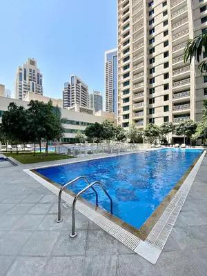 a large swimming pool in a city with tall buildings at Silkhaus near Burj Khalifa in 1BDR in 29 BLVD in Dubai