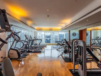 a gym with rows of treadmills and ellipticals at Stylish Studio Escape in the Heart of JLT in Dubai