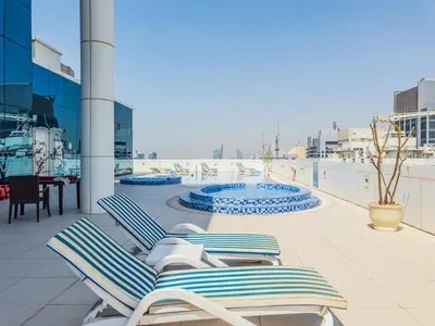 a row of lounge chairs sitting on a balcony at Stylish Studio Escape in the Heart of JLT in Dubai
