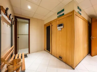 a bathroom with a shower and a wooden wall at Stylish Studio Escape in the Heart of JLT in Dubai