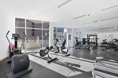 a gym with treadmills and cardio equipment in a building at Stylish Escape with Balcony, Canal and Burj Khalifa Views Near Dubai Mall in Dubai