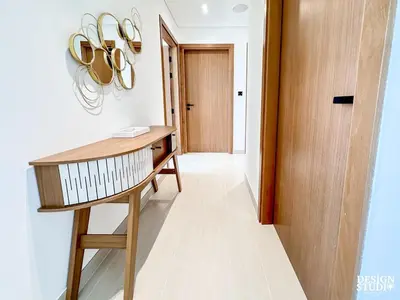 a hallway with a wooden desk and a door at GOLDEN NUMBER by Design Studio in Dubai