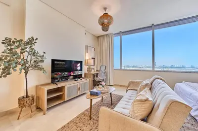 a living room with a couch and a tv at Sleek DIFC Studio Perfect for Business & Leisure in Dubai