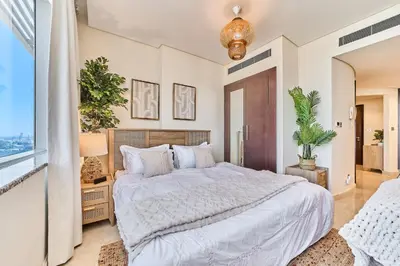 a bedroom with a large bed and a large window at Sleek DIFC Studio Perfect for Business & Leisure in Dubai
