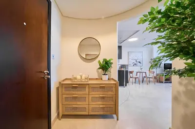 a hallway with a wooden dresser and a mirror at Sleek DIFC Studio Perfect for Business & Leisure in Dubai