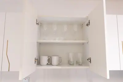 a shelf with glasses and mugs in a kitchen at Stunning City Views and Outdoor Pool, Steps from Iconic Burj Khalifa in Dubai