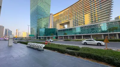 a city street with a large building and cars on the road at Stunning City Views and Outdoor Pool, Steps from Iconic Burj Khalifa in Dubai