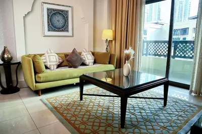 a living room with a couch and a glass table at Full View Burj Khalifa and Fountains -Souk Al Bahar- Dream View holiday Home Rental in Dubai