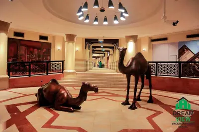 a statue of a camel and a camel laying on the floor of a lobby at Full View Burj Khalifa and Fountains -Souk Al Bahar- Dream View holiday Home Rental in Dubai