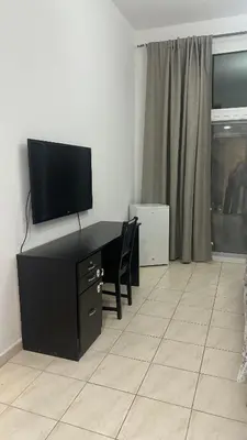 a living room with a desk with a flat screen tv at Katkeys in Dubai