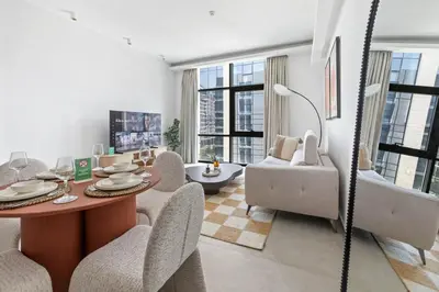a living room with a table and chairs at New 1BR with Walk-in Wardrobe in Greenish Community in Dubai