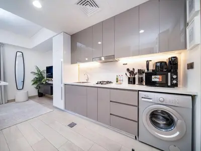 a kitchen with a washer and a washing machine at Bright and Sleek Azizi Studio Prime Meydan Location in Dubai