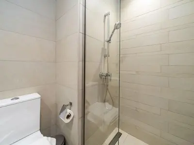 a bathroom with a glass shower with a toilet at Bright and Sleek Azizi Studio Prime Meydan Location in Dubai